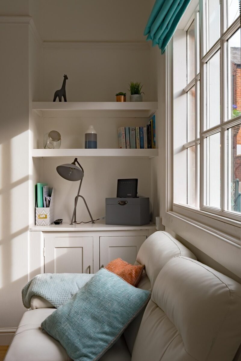 Fitted alcove cabinetry and shelving beside a chimney breast