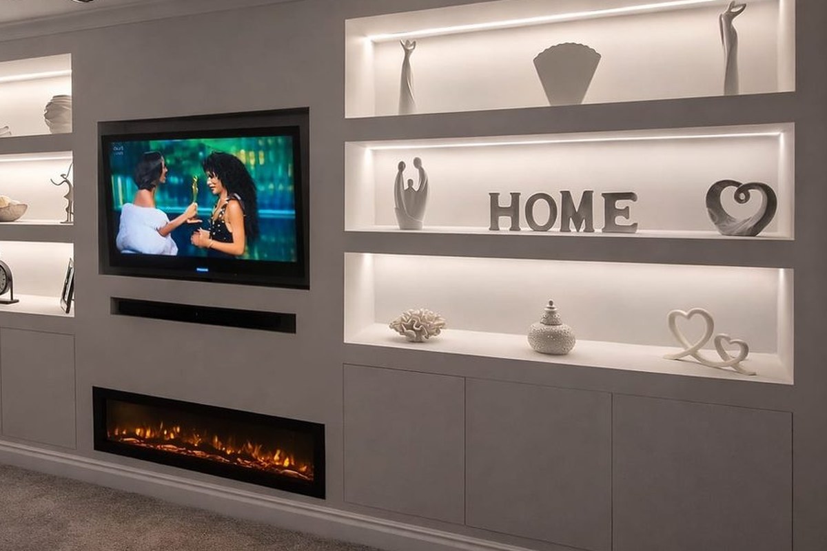 Bespoke media wall with a recessed television, inset electric fire and lit display niches